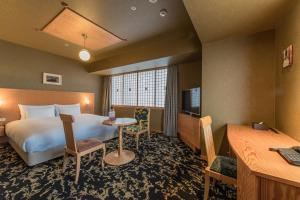 大分大分JR九州布鲁斯姆酒店的配有一张床和一张书桌的酒店客房