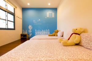 小琉球岛月掬生态旅游民宿 的两个泰迪熊坐在一个房间里的床边