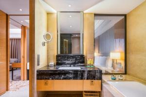 成都成都东方广场假日酒店的一间带水槽、浴缸和镜子的浴室