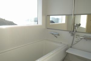 直岛町MY LODGE Naoshima的白色的浴室设有浴缸和窗户。