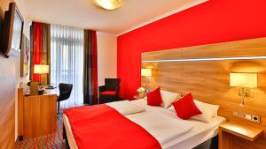 慕尼黑瓦利斯酒店的红色卧室配有红色枕头的床