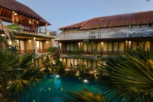 乌布Purana Suite Ubud的大楼前设有游泳池的酒店