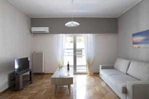 雅典Zan Moreas, A simple & minimal apartment的客厅配有白色沙发和电视