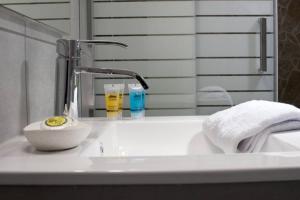 雅典Zan Moreas, A simple & minimal apartment的浴室水槽设有水龙头和镜子