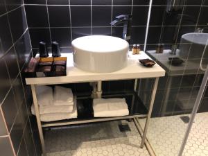 台北Hotel PaPa Whale的一间带水槽和架子毛巾的浴室