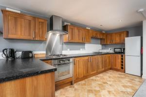 艾尔Granary Suite No22 - Donnini Apartments的厨房配有木制橱柜和白色冰箱。