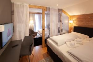 达米尔斯Dà Ingo - Apartments & More的酒店客房配有一张床和一张书桌及一台电视