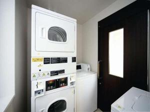 大阪西乐雷斯酒店的厨房配有洗衣机和烘干机。