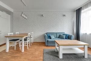 索波特Willa Morska Superior by Grand Apartments的客厅配有蓝色的沙发和桌子