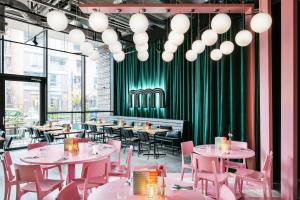 格罗宁根The Social Hub Groningen的一间带桌椅和绿色窗帘的餐厅