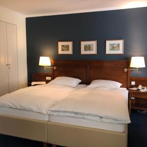 巴特利普施普灵格舍夫酒店的一间卧室配有一张带两盏灯的大型白色床。