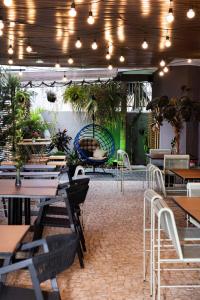 乌贝兰迪亚Hotel Parati Minas的一间设有桌椅和盆栽的餐厅