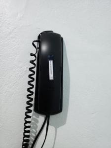 吉巴拉那Hotel Chalé Ji-Parana的挂在墙上的黑色电话