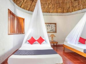 San JoséHotel Villas del Ángel的一间卧室配有两张带红色枕头的床
