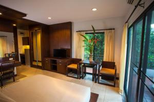 清迈桑宁静旅馆的客厅配有桌椅和电视。