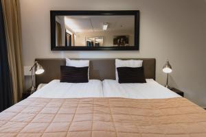 塞伊奈约基索桑佩萨酒店的一间卧室配有一张大床和大镜子
