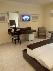 米德兰别墅酒店 - 米德兰的一间卧室配有一张床、一张书桌和一台电视