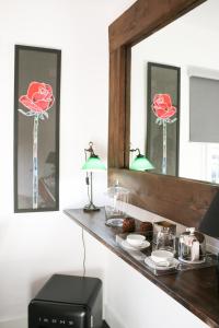 圣塔克里斯蒂纳阿鲁Suite Garden House的镜子在柜台上,上面有玫瑰花