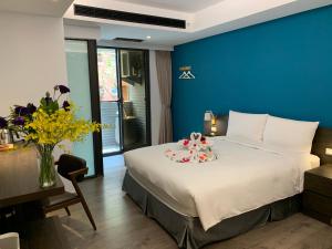 台中市绿夜文旅的一间卧室设有一张蓝色墙壁的大床