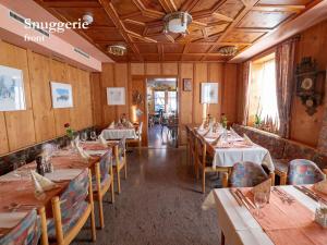 菲利苏尔Hotel Restaurant Rätia的餐厅拥有木墙和桌椅