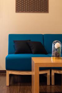 大阪Bijou Suites Miyabi的一张蓝色的沙发,坐在木桌旁