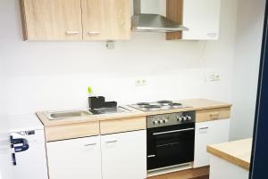 埃默里希Work & Stay in Emmerich的厨房配有白色橱柜、炉灶和水槽。