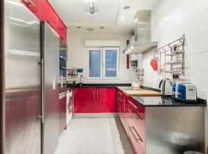 毕尔巴鄂Casa txema tu casa en Bilbao by Urban Hosts的一间带红色橱柜和冰箱的厨房