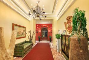 巴登Das Gutenbrunn Thermen & Sporthotel的走廊上设有红地毯和吊灯