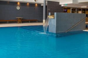 派尔努爱沙尼亚医疗温泉酒店 的一座大楼内带水滑梯的游泳池