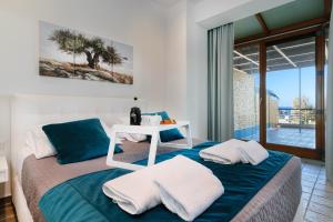 加藤-达拉特索Xenios Dias Luxury Apartments With Sea View的一间卧室配有一张床、一张桌子和毛巾