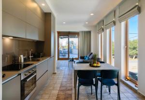 加藤-达拉特索Xenios Dias Luxury Apartments With Sea View的厨房以及带桌椅的用餐室。
