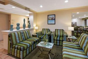 黎明城La Quinta Inn & Suites by Wyndham Sawgrass的一间设有两把椅子和一张桌子的等候室