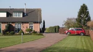 SteenderenB&B Bij Bronckhorst的停在房子前面的红色汽车