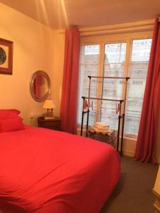 SennelyAuberge de villechaume的一间卧室设有红色的床和窗户。