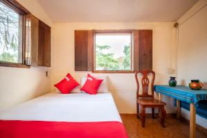 马祖特OYO Cabañas Abril, Mazunte的客房设有床、书桌和窗户。