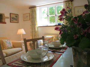 QueningtonMayfly Cottage的客厅配有带盘子和酒杯的桌子