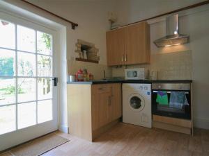 QueningtonMayfly Cottage的厨房配有洗衣机和窗户。