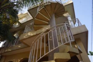 Grand-PopoRamaya Auberge Espagnole的棕榈树前的一座带螺旋楼梯的建筑