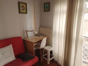 桑坦德Apartamento centro Santander的客房设有书桌、红色椅子和书桌。