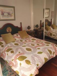桑坦德Apartamento centro Santander的一间卧室设有两张床和两张带镜子的桌子。
