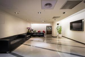 台北洛碁大飯店新仕界的大堂配有黑色家具和平面电视。