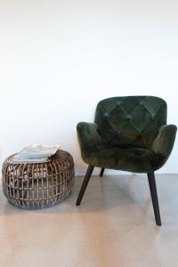 戈伊斯霍夫欧曼斯特恩公寓的一张绿色椅子和一个桌子旁边的篮子