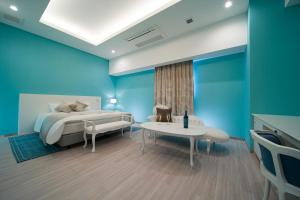 和歌山HOTEL LASCALA的一间拥有蓝色墙壁的卧室,配有一张床和一张桌子