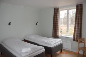 GräddöSTF卡佩尔斯卡乡村民宿的带窗户的客房内的两张床
