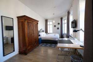兰河畔马尔堡Elisabeth Apartments的一间卧室配有一张床、一张书桌和一面镜子