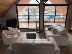 维拉摩拉Beach Apartment Marina Vilamoura的客厅配有白色家具和大窗户