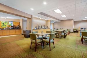 西塔科拉群塔西雅图西塔机场酒店&套房的一间带桌椅的餐厅和一间酒吧