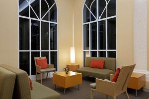 黎明城日出拉库恩塔旅馆及套房酒店的客厅设有2个大窗户、1张沙发和椅子