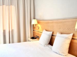 阿让塔勒勒巴Maison Jenny Hotel Restaurant & Spa的配有两张枕头的床的酒店客房