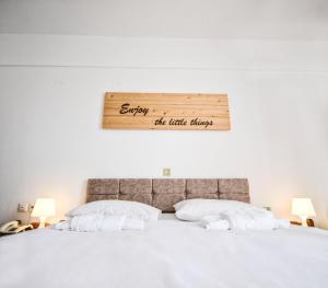 阿基奥斯基利考斯Κastro Ηotel的一张铺有白色床单的床,墙上有标志